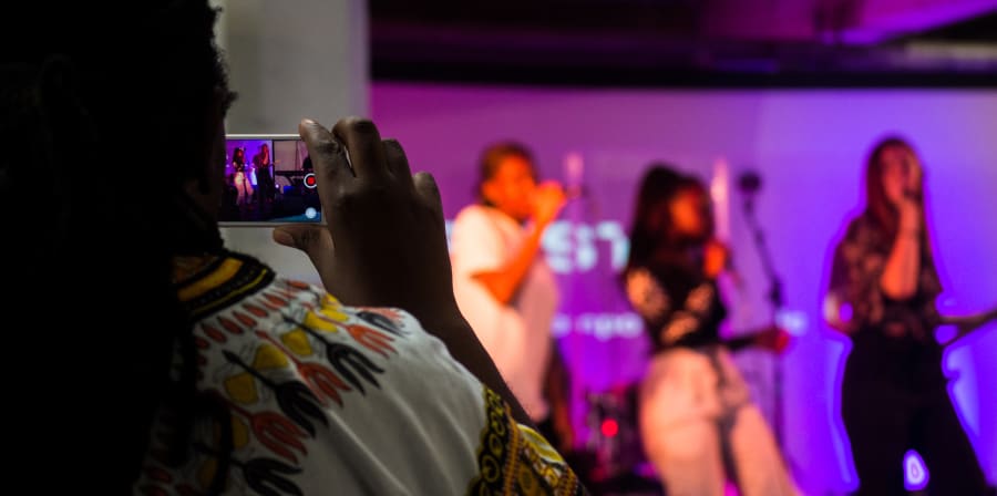 An audience member filming a performance on their phone