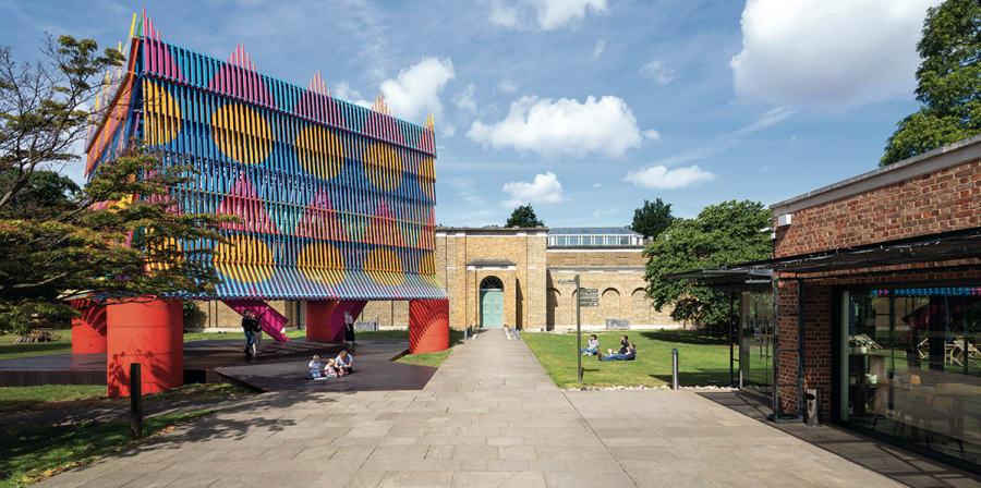 Image depicts a brightly coloured structure, the Colour Palace, erected in front of Dulwich Picture Gallery.