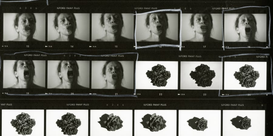 Contact sheet of black and white 35mm positive film showing images of a woman's face, some with a distorted mouth, and images of roses