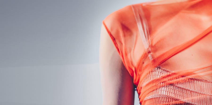 Orange mesh sleeveless dress closeup on grey background