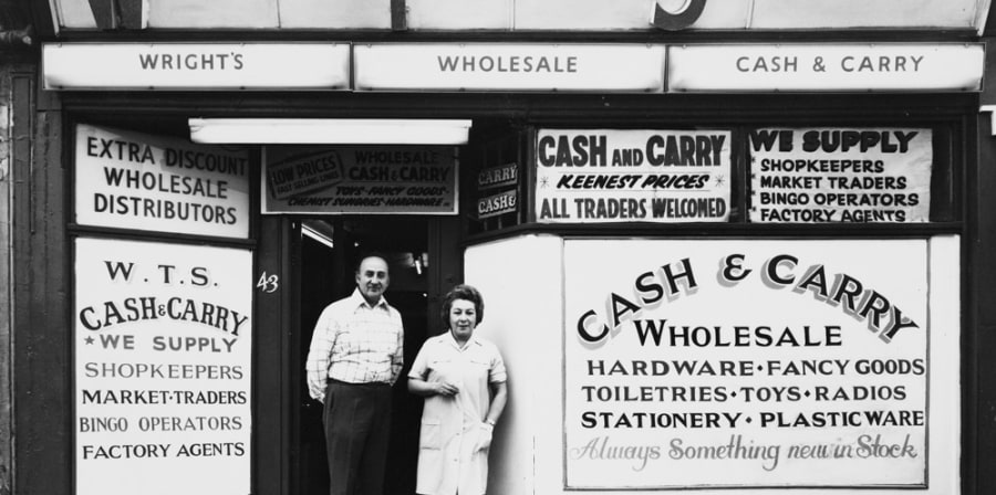 Black and white photo of couple stood outside cash and carry in 1975.