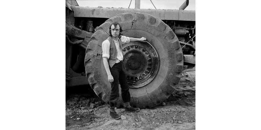 Photograph of a man standing next to a tractor