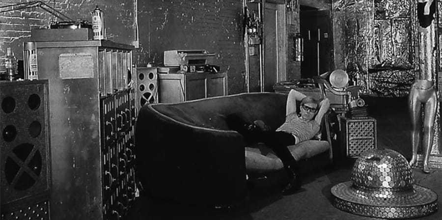 Black and white image of Andy Warhol in his studio