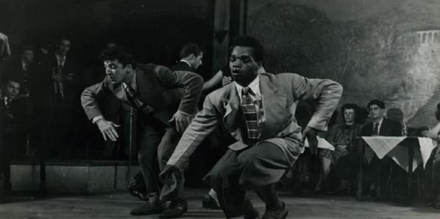 a black and white picture of two men in suits dancing
