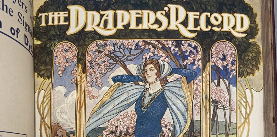 Fashion illustration with the title 'The Drapers' Record', featuring a woman in a blue dress with long flowy sleeves and scarf headpiece, in front of a background of blue skies, cherry blossoms and trees.