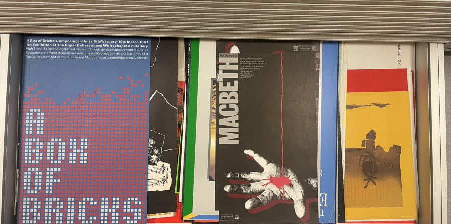 A view upon posters of various colours in a metal plan chest drawer.