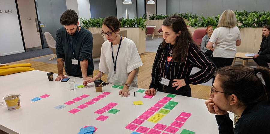 Rafa and his colleagues collaborate on a project over a table of post-it notes.