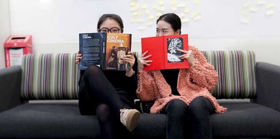 Two students holding books at LCC Library