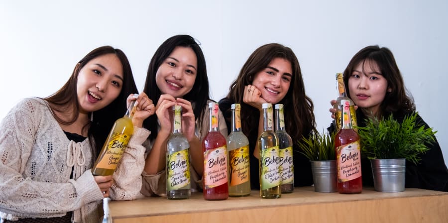 Students posing with the bottles designed by them