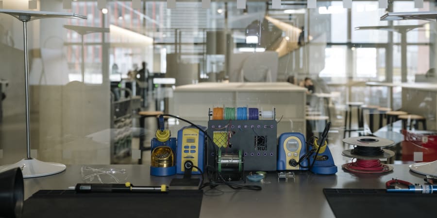 Worktable with sewing equipment, goggles, and a light.