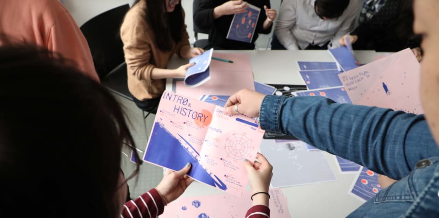 Students folding prints to make their data visualisation zine