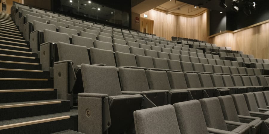 Staggered lines of grey seats next to steps.