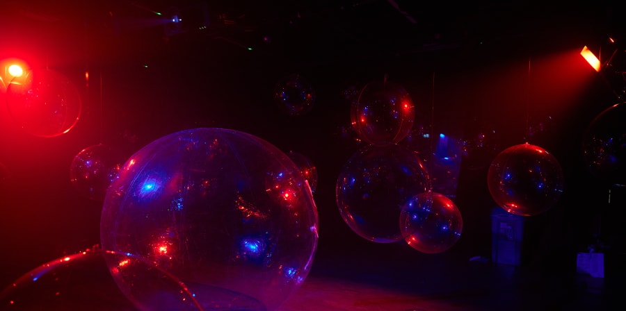 A model set of hollow cubes hanging from the ceiling, below is a male figurine standing, the set is blue