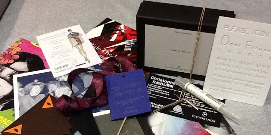 A selection of London Fashion Week invitations from Autumn / winter 2014,  spread out across a table
