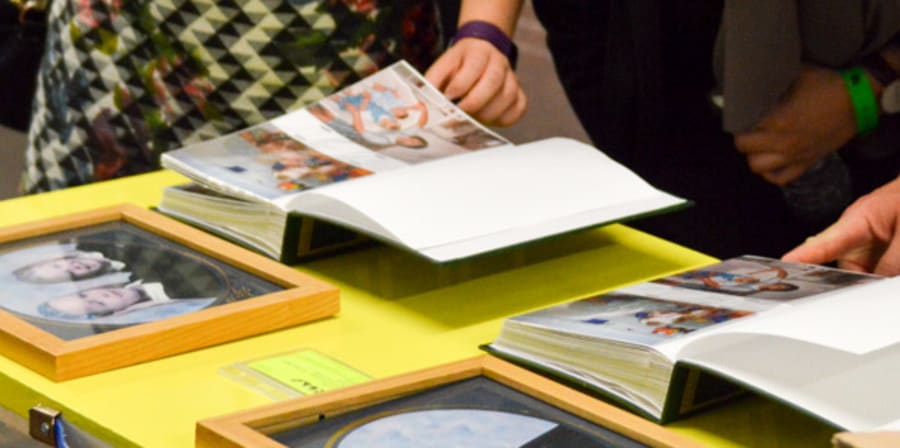 People look through photography in sketch books on display at Origins