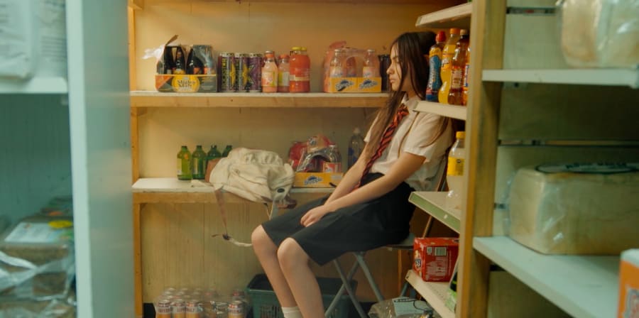 A student waits in a shop's stock-room.