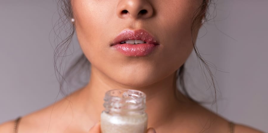 Model holding a jar of lip balm.