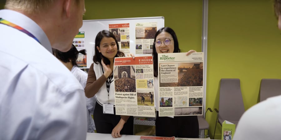 A person looking at two people holding up a chart