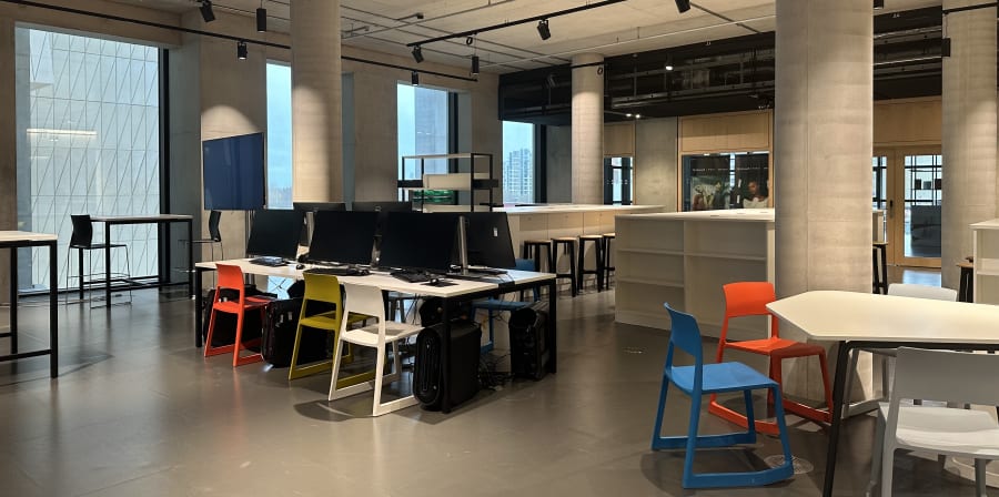 Large room with colourful chairs and computers.