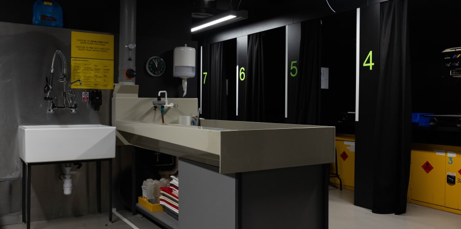 Room with sinks and small rooms with black curtains