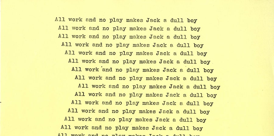 Yellow paper with black typewritten text reading 'All work and no play makes Jack a dull boy' repeatedly