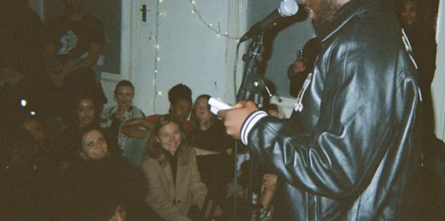 a man at a mic with people watching