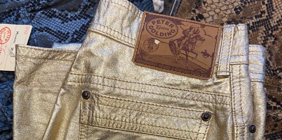 A close up photo of gold jean pockets with Peter Golding logo tag