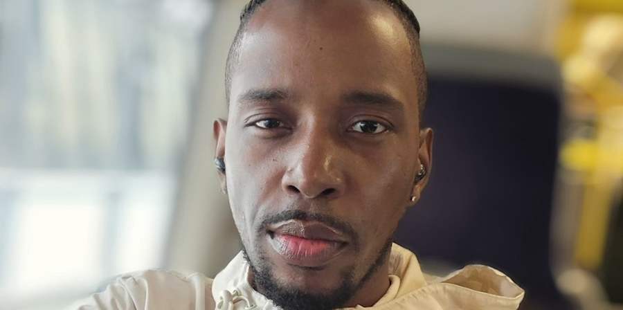 Portrait of a person wearing a light-coloured jacket, photographed indoors with a blurred background.