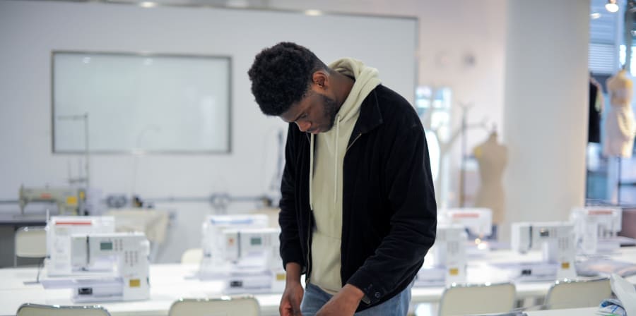 Student constructing their fashion piece in a production room.