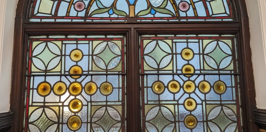 Colour photograph of an arched geometric stained glass window