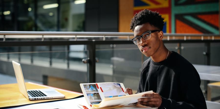 A student looks through their portfolio of work at a desk in Central Saint Martins