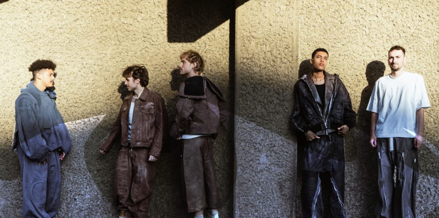 Line up of male models covering different looks, sun hitting the steps.