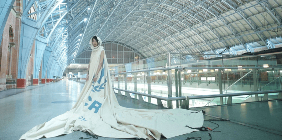 Dress for Our Time: The dress is created out of a decommissioned UNHCR refugee tent from Zaatari Camp, Jordan. Dress worn at overnight film shoot at St Pancras Station. Image by David Betteridge.