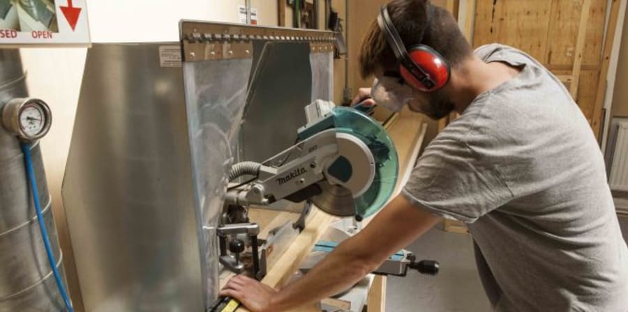 A student cutting wood with a circular saw 