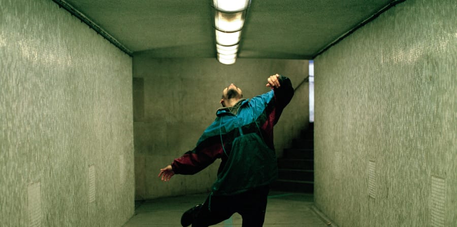 model dancing in walkthrough subway, posed looking up at the lights