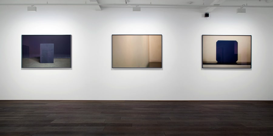 Three paintings sit on a gallery wall.