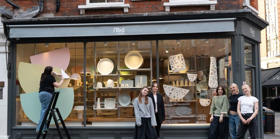 This is a photo of the Marylebone Mud Australia window display of the winning campaign. 5 students from the winning team are posing in front of the window display and 1 is installing the work.