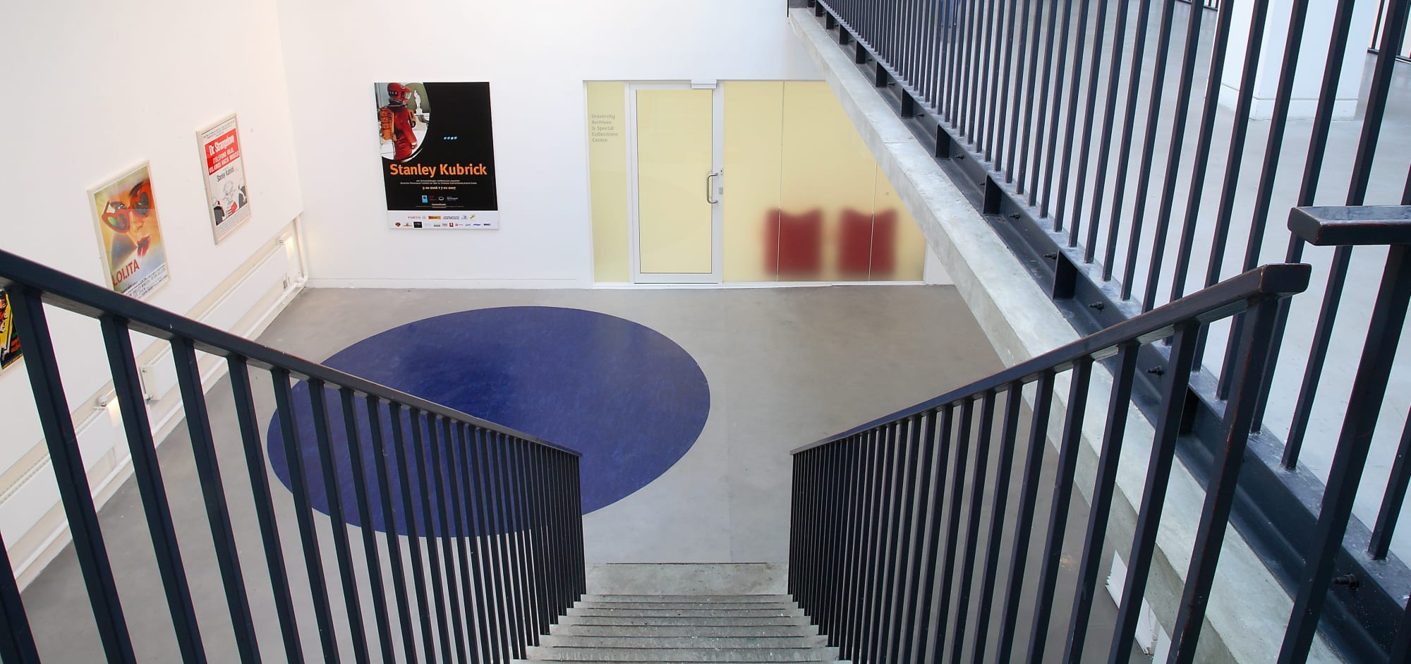 Flight of stairs leading to gallery space with door to archive
