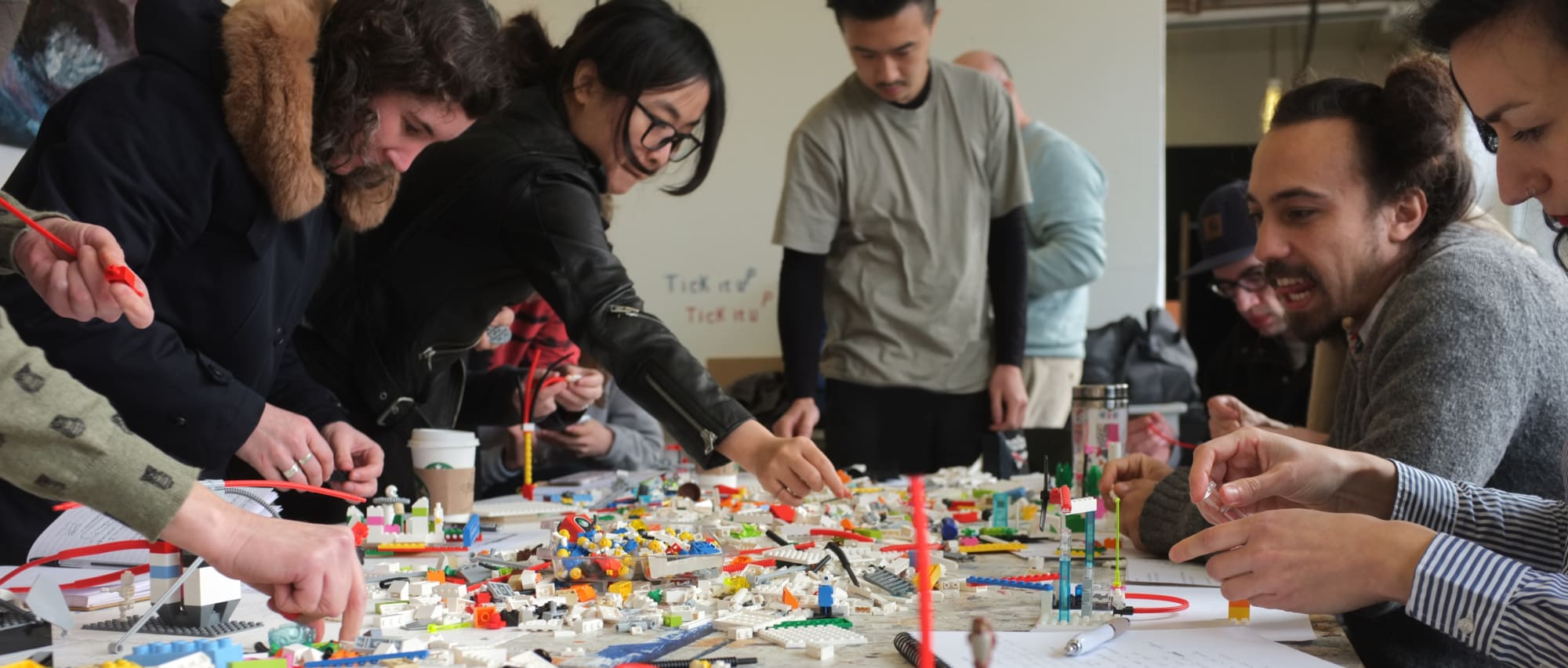 Students working at a table with legos in a creative workshop.