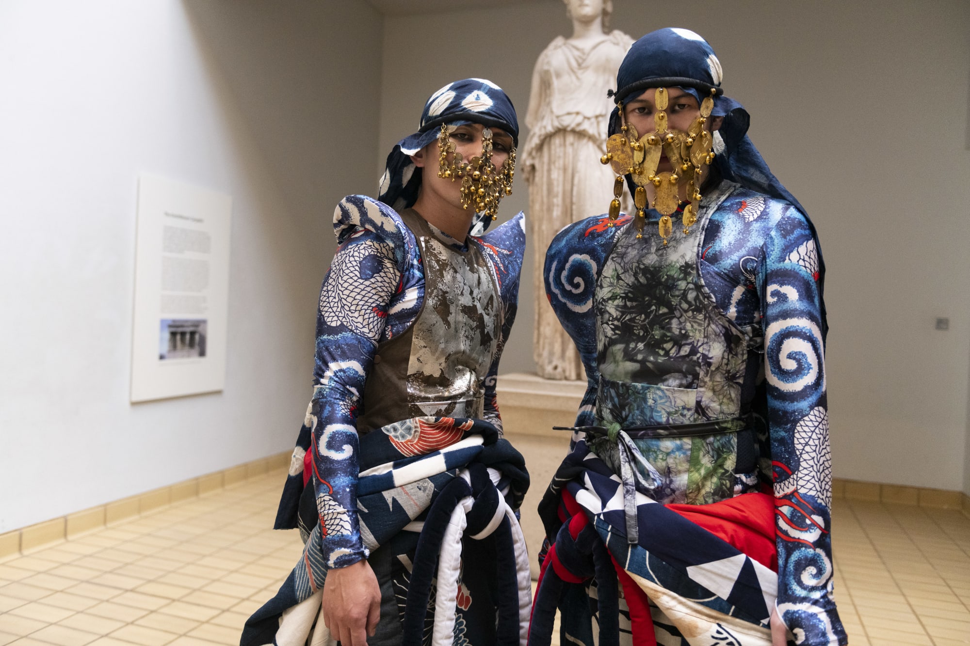 Warriors with intricate gold masks, eye makeup and blue costumes