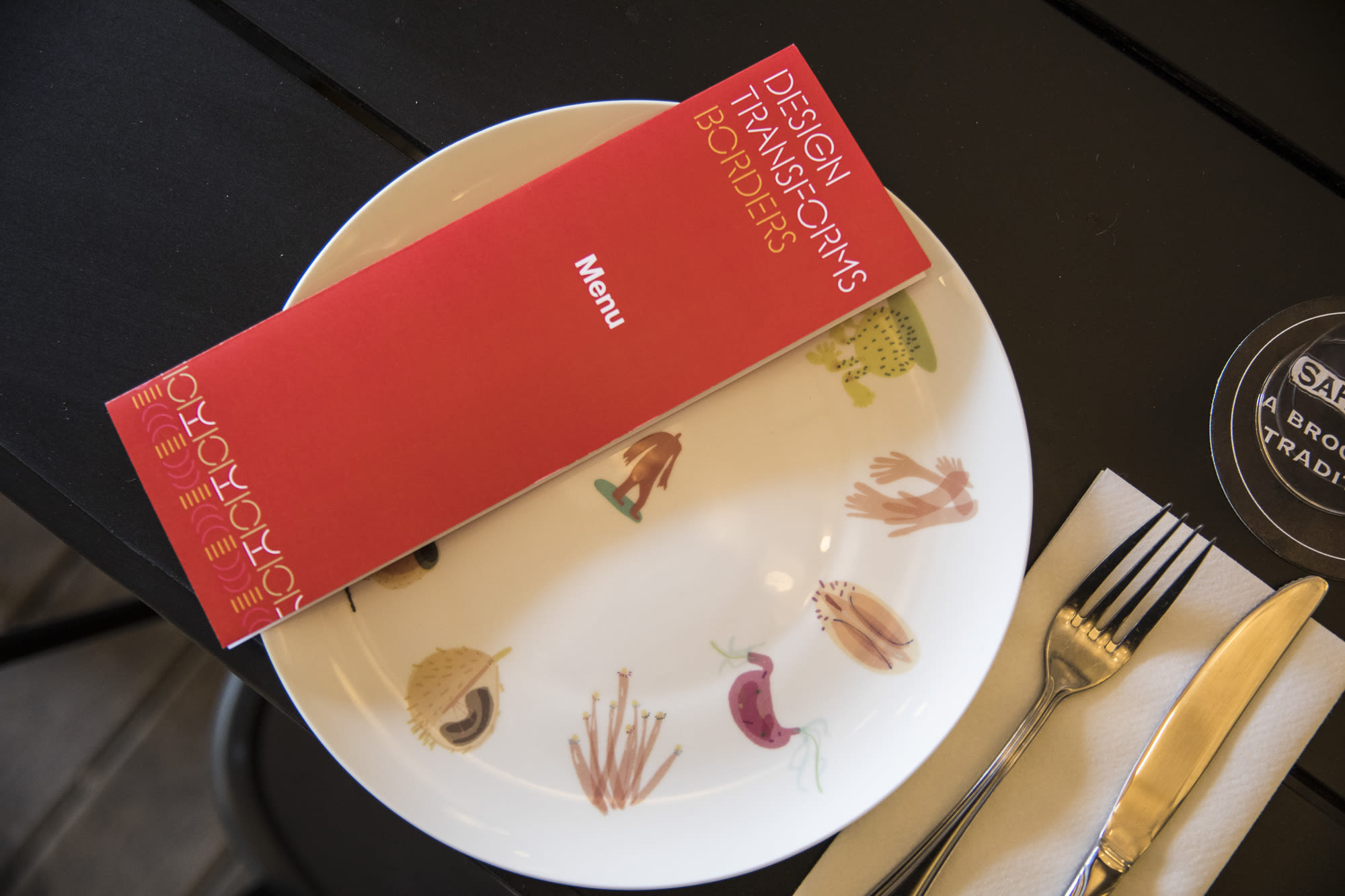 A large wall panel with a map of the world and red thread and the words 'Design Transforms Borders' and 'Where is home' and 'Territorial Empathy'