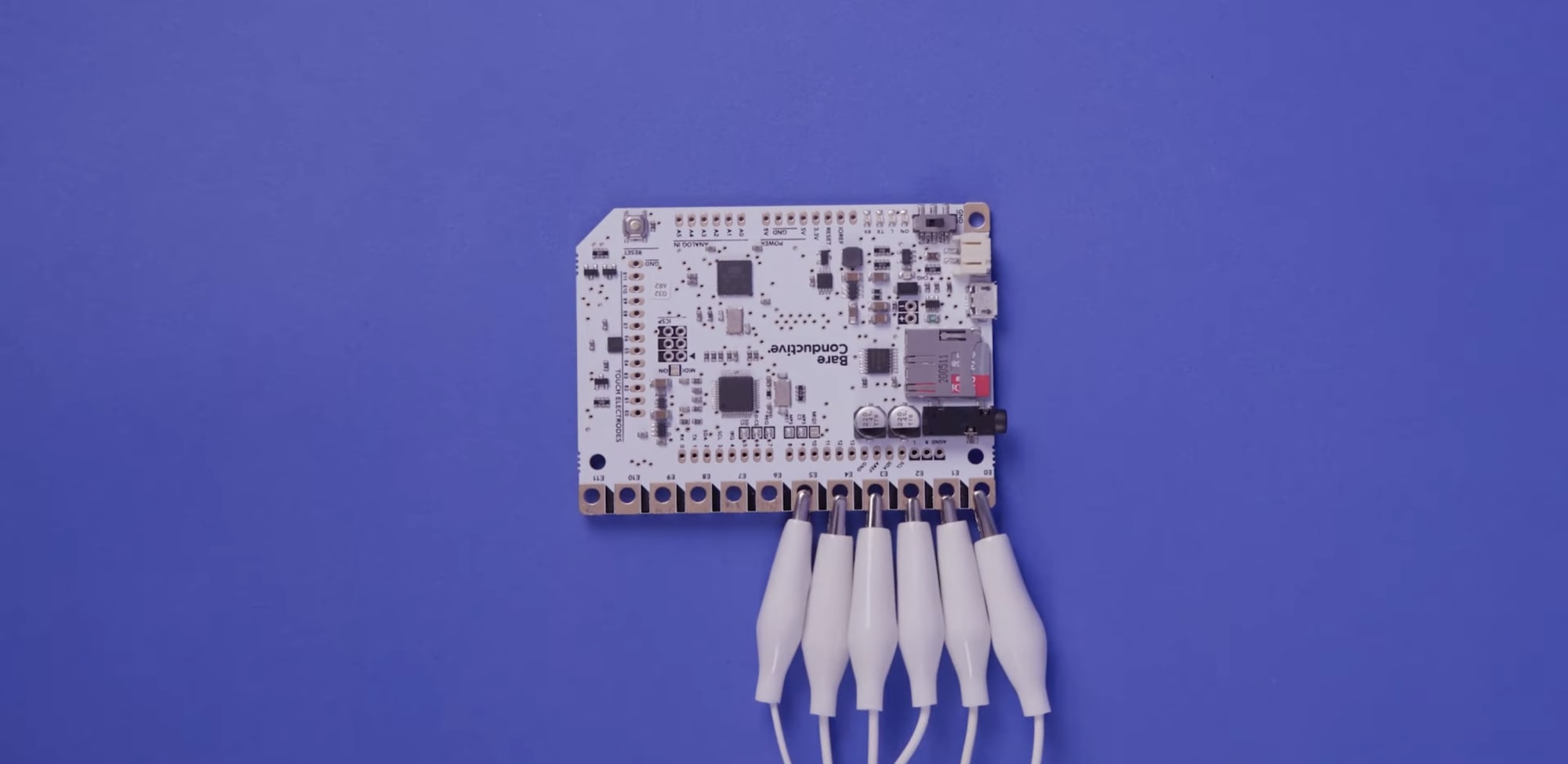 A  motherboard on a blue background with crocodile clips