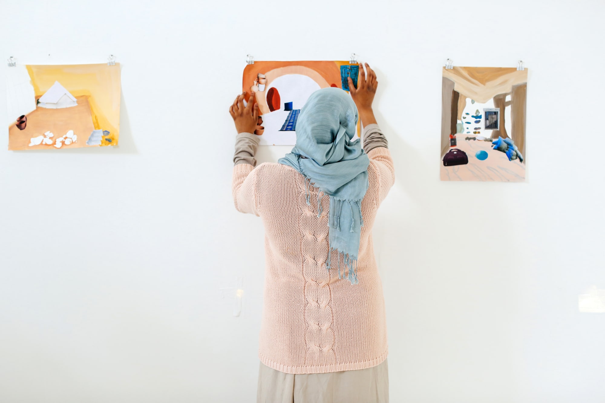 A person hanging arts on the wall