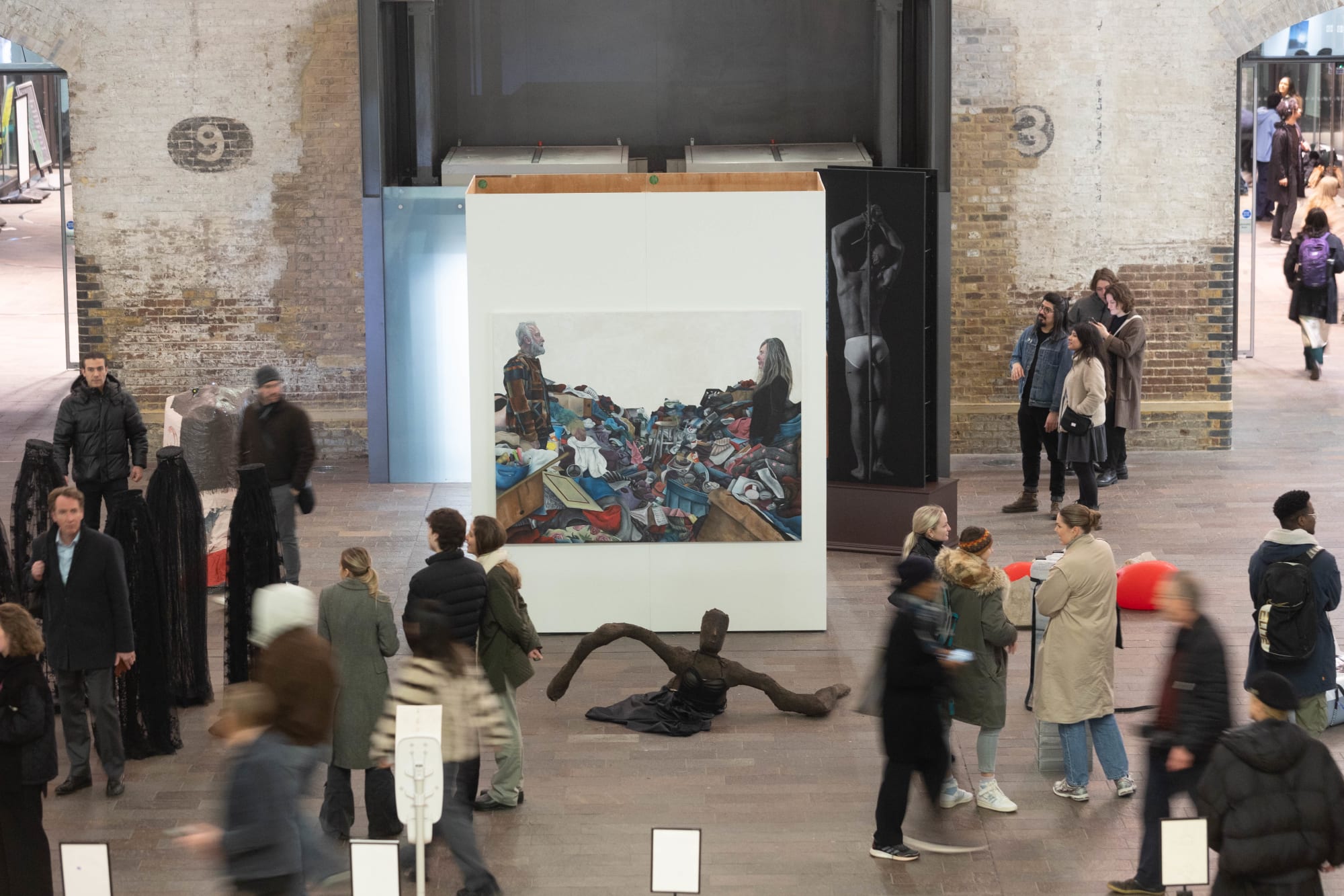 A large installation and sculpture inside the Crossing at Central Saint Martins, which is busy with visitors, shot from a slightly higher angle.