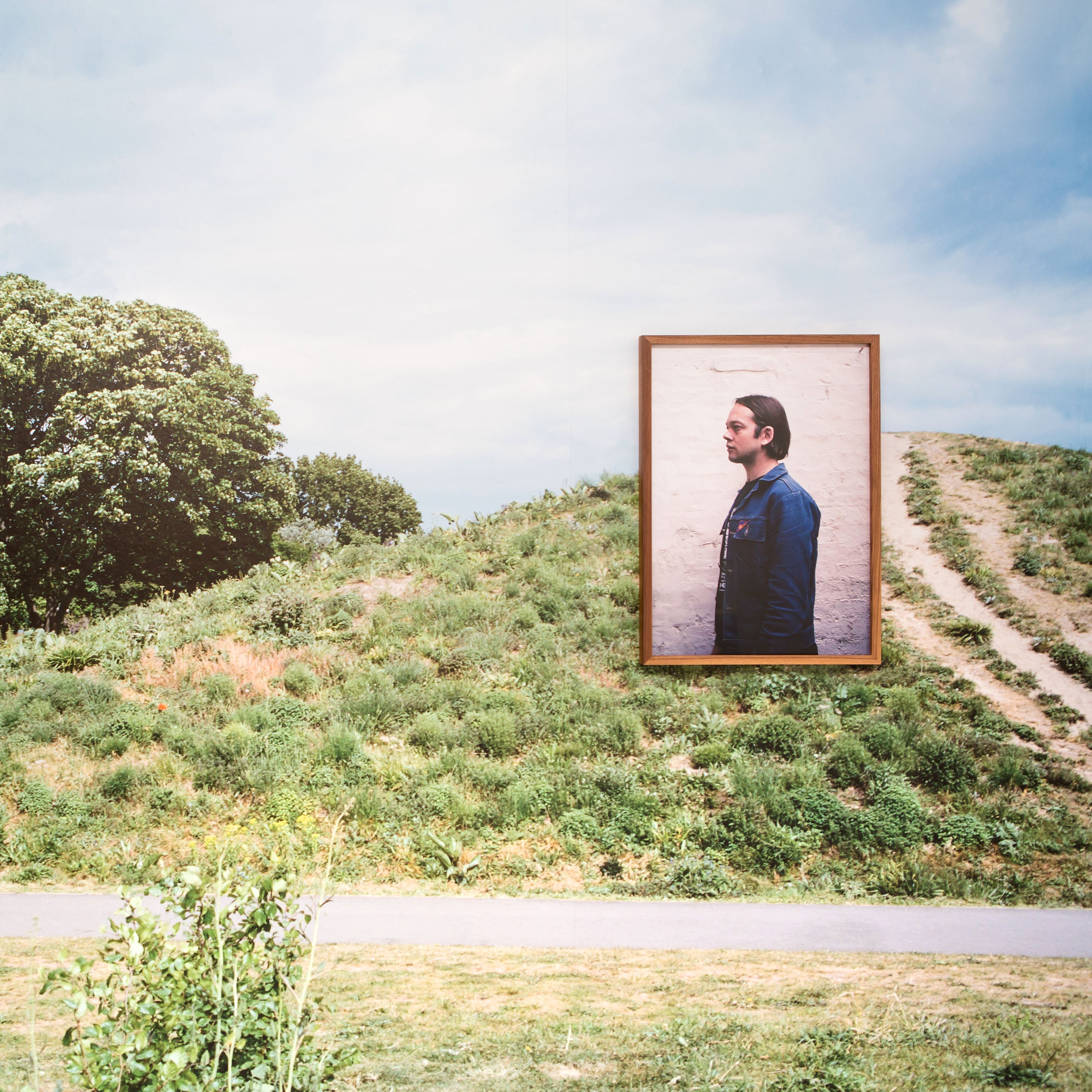 Green space with a large photography installation of a man.   