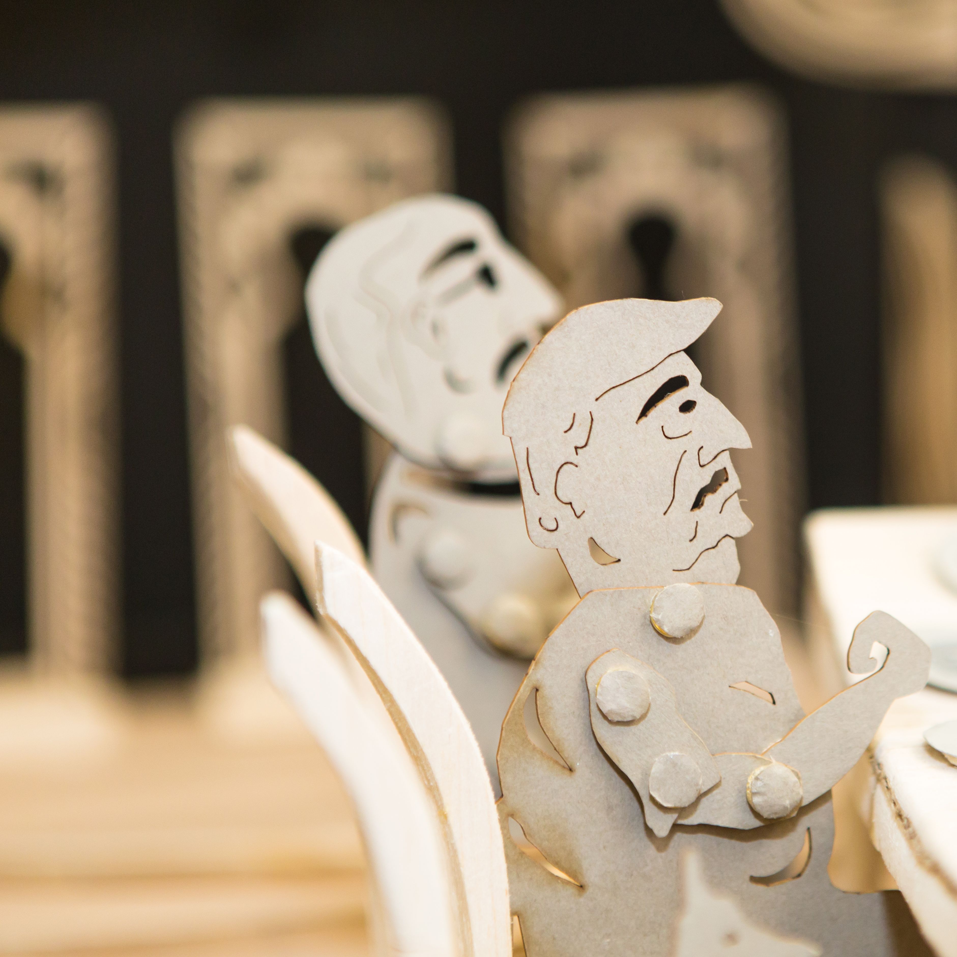 Cardboard characters at a dinner table - part of BA Live Events and Television course project