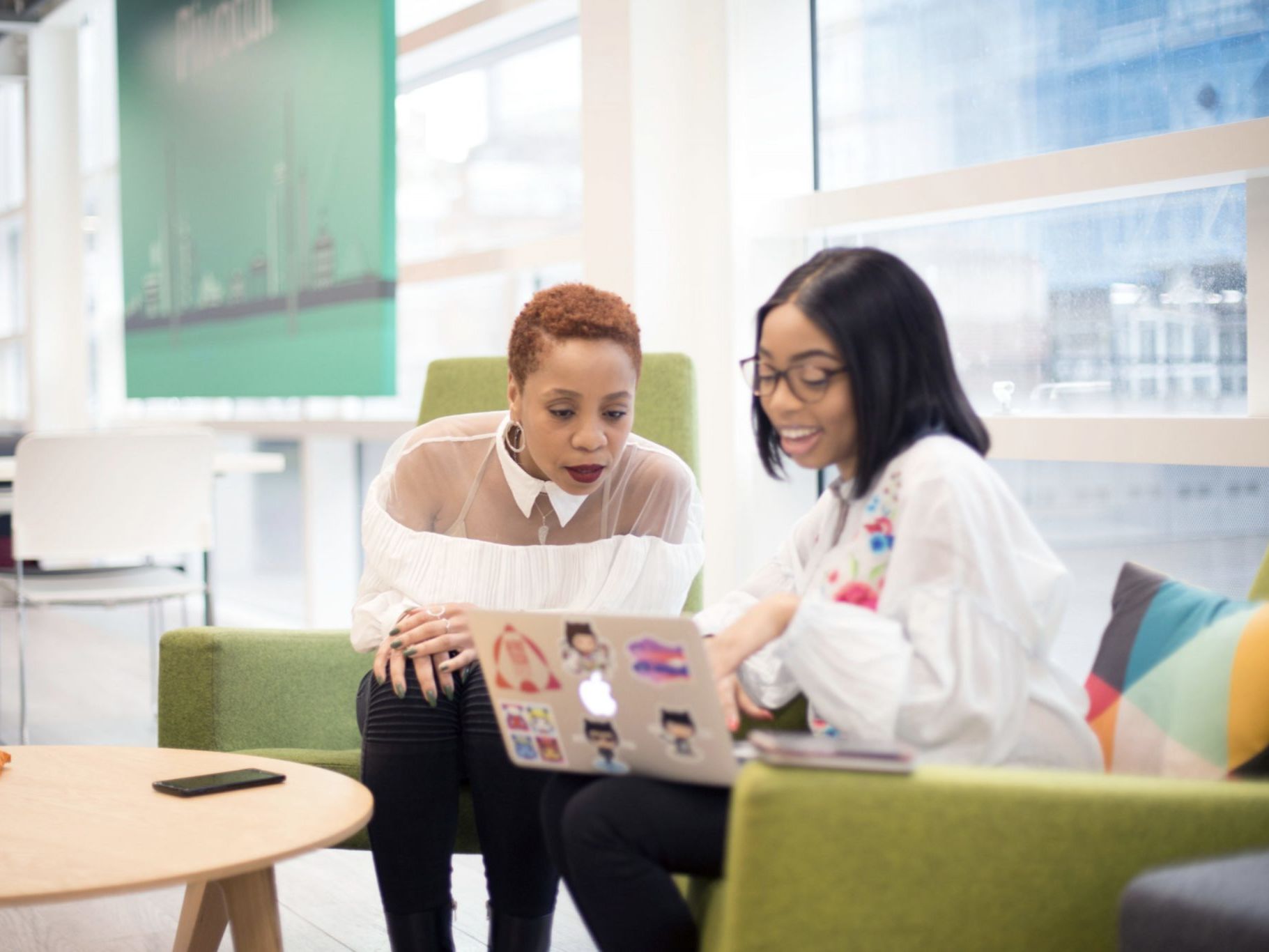 Two people talking and looking at a computer screen