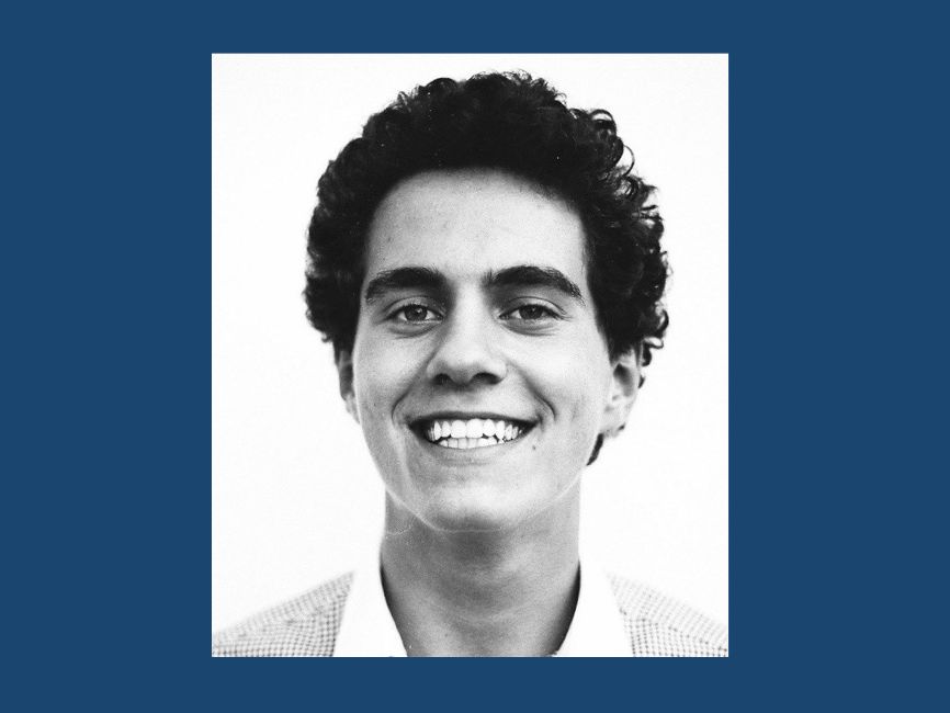 A greyscale portrait of a smiling man.