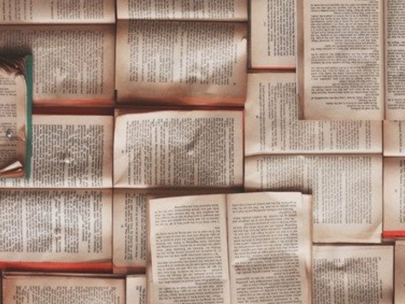 books opened flat and piled together