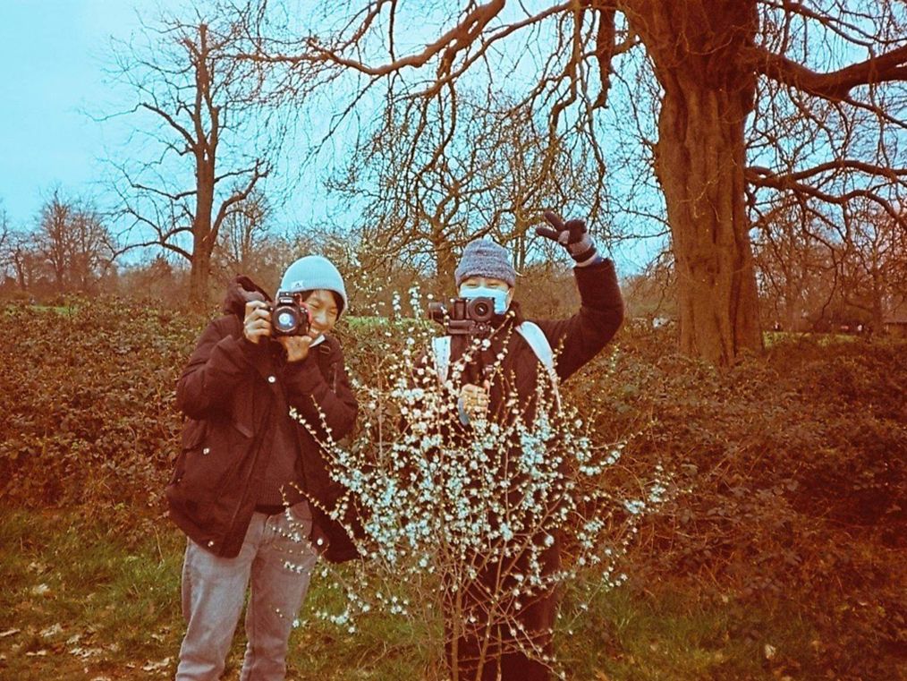 Photograph of two people in a forest setting.